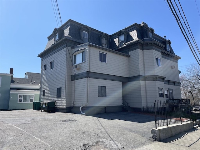 74 Newhall Unit 9, Lynn, MA 01902 - view of home's exterior featuring mansard roof, fence, and a shingled roof