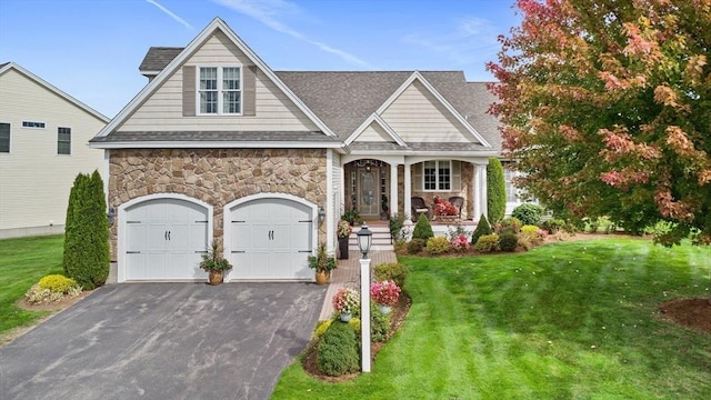 view of front of house featuring a porch, a garage, and a front lawn