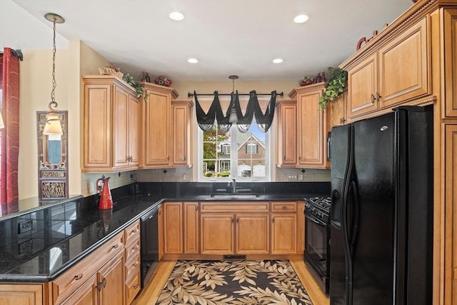 kitchen featuring light wood-type flooring, backsplash, sink, black appliances, and decorative light fixtures