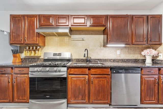 kitchen with a sink, extractor fan, dark stone counters, stainless steel appliances, and backsplash