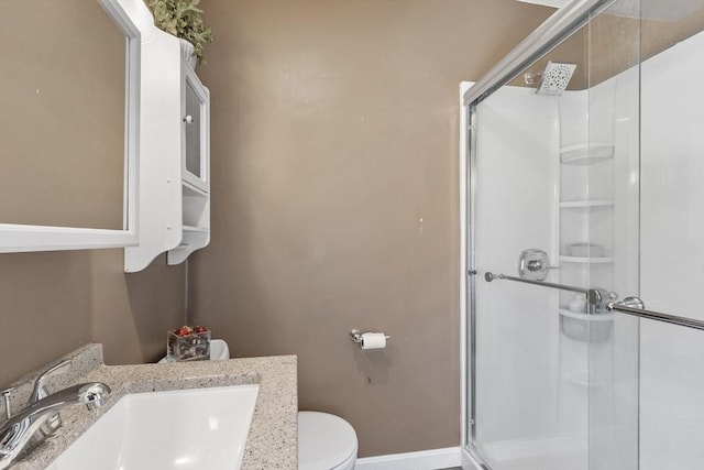 full bathroom with vanity, baseboards, a stall shower, and toilet