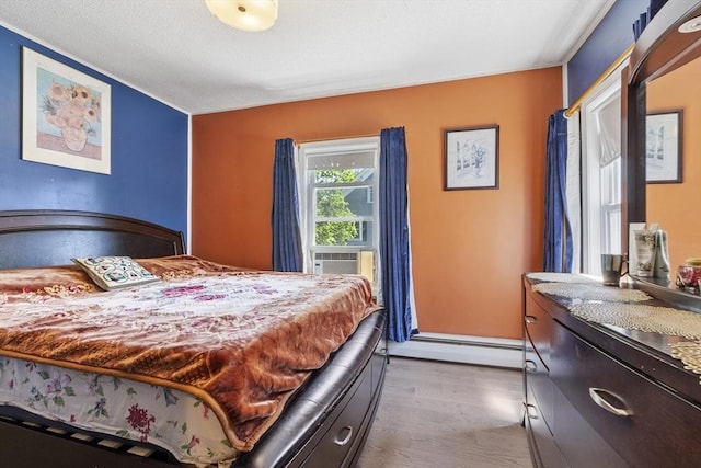 bedroom featuring wood finished floors, a baseboard heating unit, and cooling unit