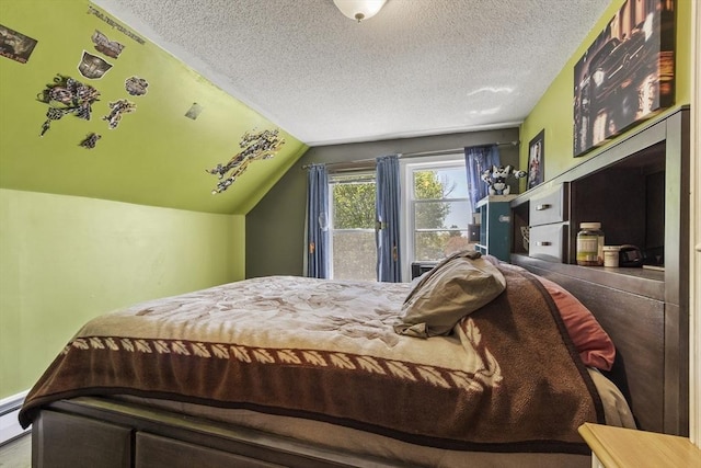 bedroom featuring a textured ceiling, baseboard heating, and lofted ceiling