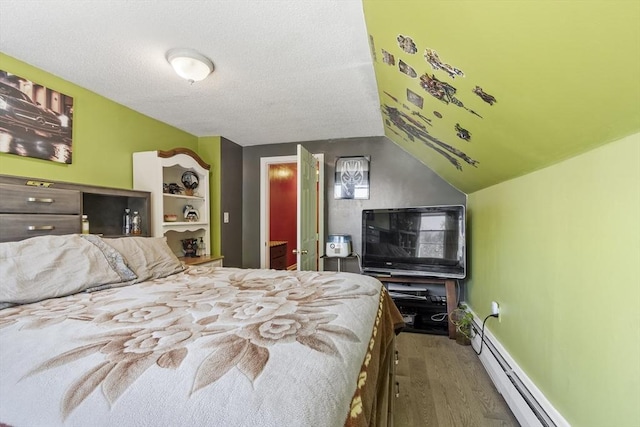 bedroom with baseboards, a textured ceiling, a baseboard heating unit, and wood finished floors