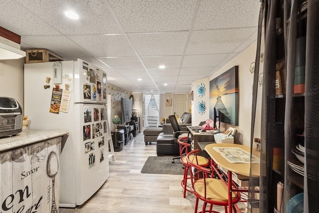 interior space with light wood-style floors, recessed lighting, and a drop ceiling