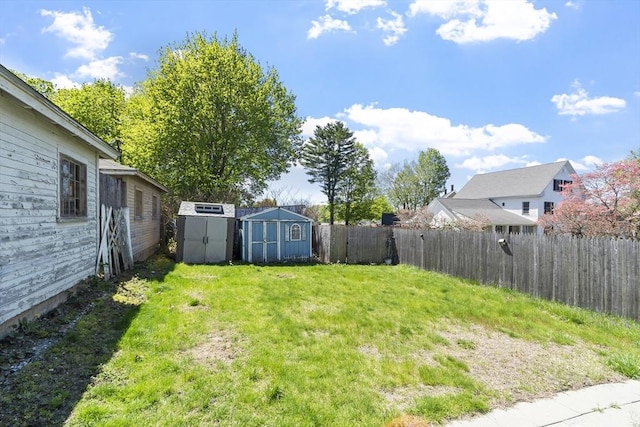 view of yard featuring a fenced backyard, an outbuilding, and a storage shed