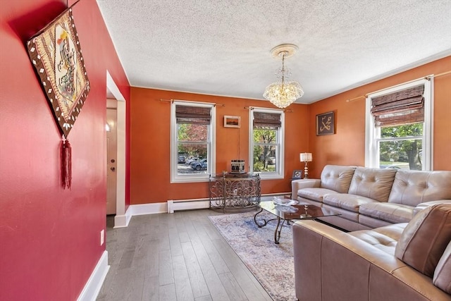 living area featuring a textured ceiling, baseboards, a baseboard radiator, a notable chandelier, and hardwood / wood-style floors