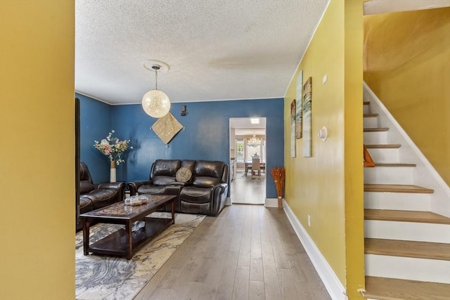 living area with stairs, a textured ceiling, and wood-type flooring