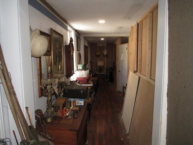 hall featuring recessed lighting, a textured ceiling, and dark wood-type flooring