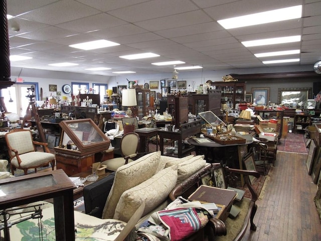 miscellaneous room featuring hardwood / wood-style flooring, a workshop area, and a drop ceiling