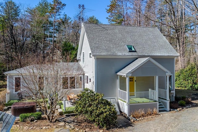 view of front of home with covered porch and a shingled roof