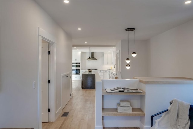 hall with sink and light wood-type flooring