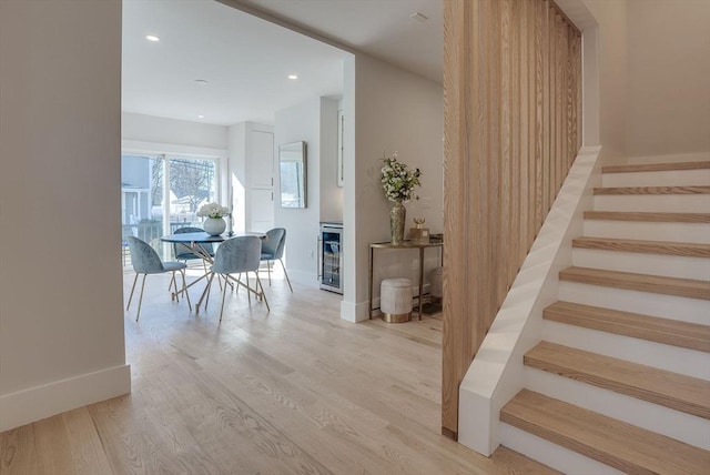 stairs featuring hardwood / wood-style floors and wine cooler