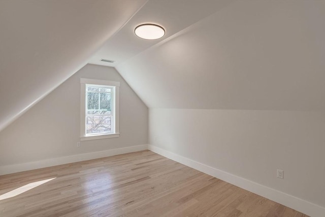 additional living space with lofted ceiling and light hardwood / wood-style flooring