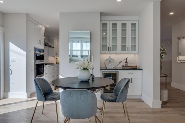 dining space featuring light hardwood / wood-style flooring and beverage cooler