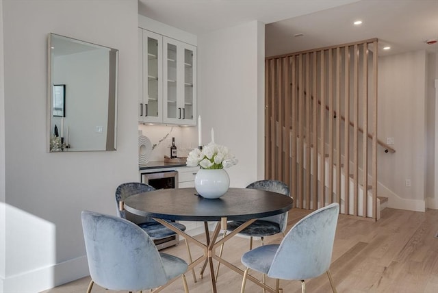 dining area with bar and light hardwood / wood-style flooring