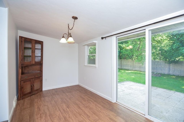 248 Levin Rd, Rockland, MA 02370 - unfurnished dining area with wood finished floors, baseboards, and a chandelier