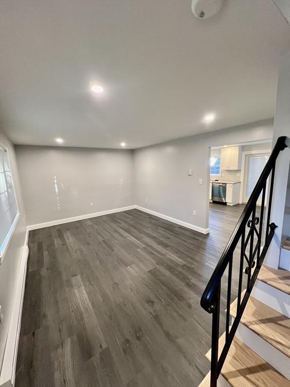 interior space with dark hardwood / wood-style flooring, plenty of natural light, and baseboard heating