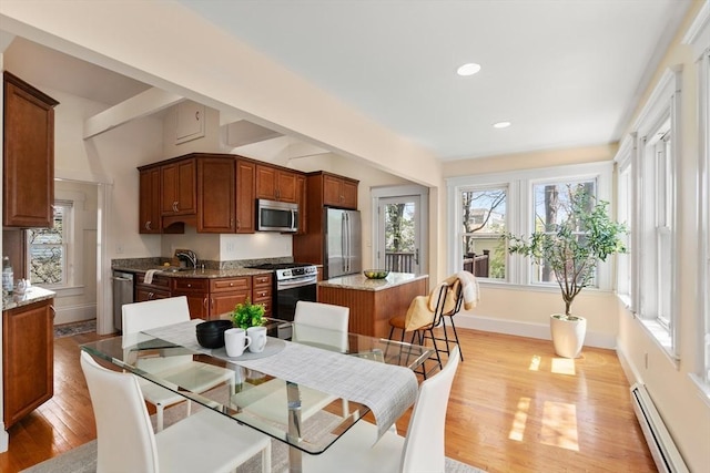 dining space with baseboards, baseboard heating, recessed lighting, light wood-style flooring, and vaulted ceiling