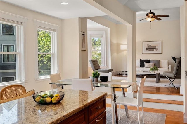 dining space featuring recessed lighting, a ceiling fan, a baseboard heating unit, and wood finished floors