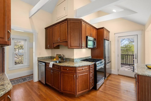 kitchen featuring a sink, appliances with stainless steel finishes, plenty of natural light, and lofted ceiling