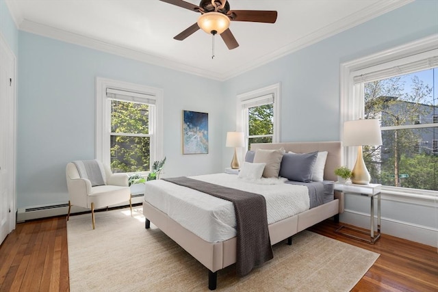 bedroom with wood-type flooring, ornamental molding, ceiling fan, and a baseboard radiator