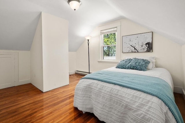 bedroom with a baseboard heating unit, lofted ceiling, and wood finished floors