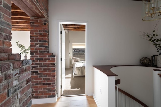 hall featuring beam ceiling and light hardwood / wood-style floors