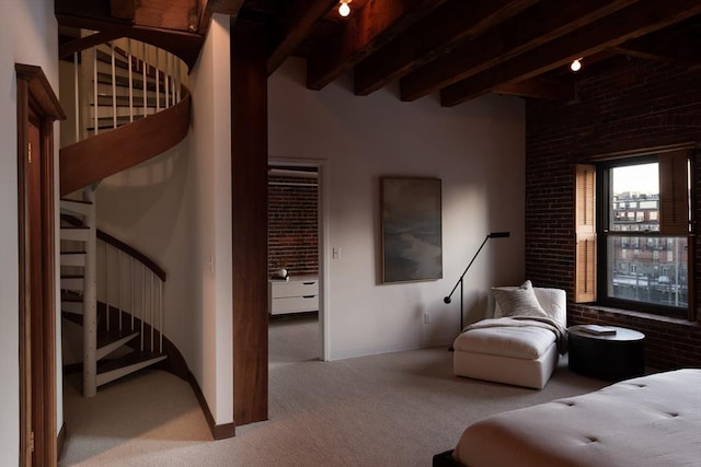 bedroom with beamed ceiling, brick wall, and light carpet