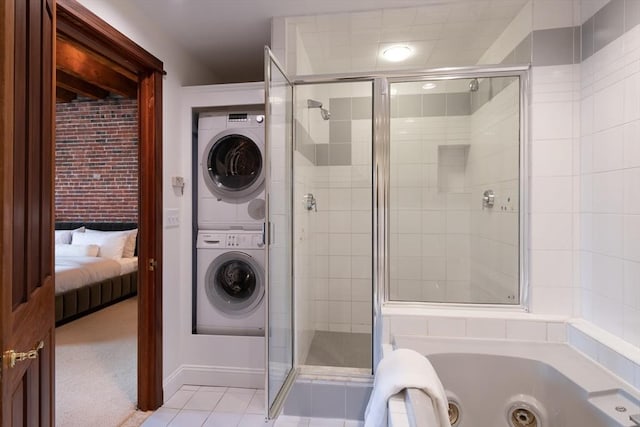 bathroom with tile patterned flooring, a shower with shower door, and stacked washer and clothes dryer