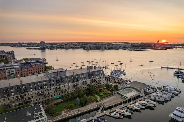 aerial view at dusk featuring a water view