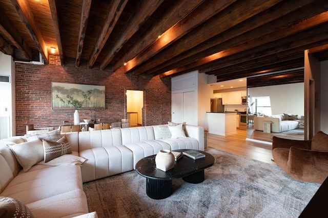 living room featuring beam ceiling, light hardwood / wood-style floors, wooden ceiling, and brick wall