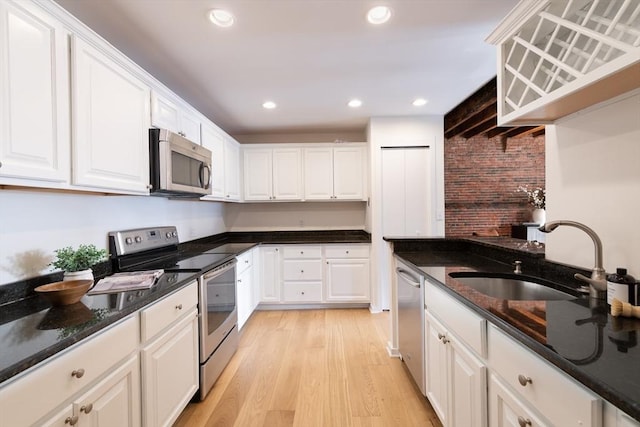 kitchen with sink, light hardwood / wood-style flooring, white cabinets, and appliances with stainless steel finishes