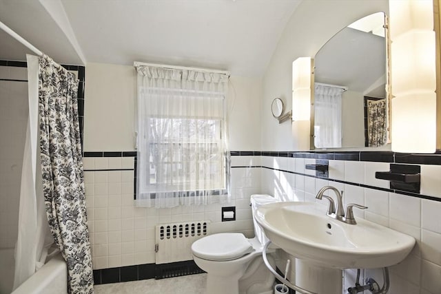 full bath with toilet, radiator heating unit, shower / tub combo, tile walls, and a sink