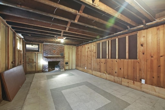 below grade area with wooden walls and a brick fireplace