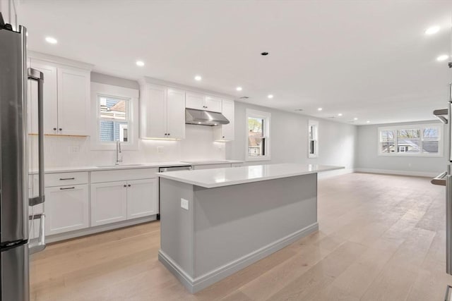 137-139 Crafts St, Newton, MA 02460 - kitchen with under cabinet range hood, a sink, light wood-type flooring, white cabinets, and recessed lighting
