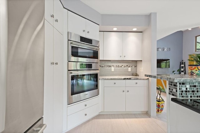 887 High Rock Rd, Fitchburg, MA 01420 - kitchen featuring appliances with stainless steel finishes, decorative backsplash, white cabinetry, and light stone counters