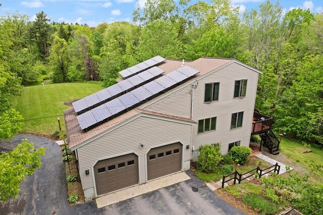 887 High Rock Rd, Fitchburg, MA 01420 - view of property exterior with roof mounted solar panels, stairway, driveway, a lawn, and a wooded view