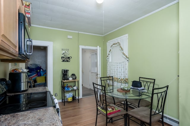 dining room featuring dark wood-type flooring, crown molding, and a baseboard heating unit