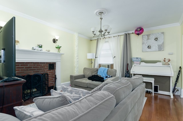 living room with a brick fireplace, ornamental molding, an inviting chandelier, and dark wood-type flooring