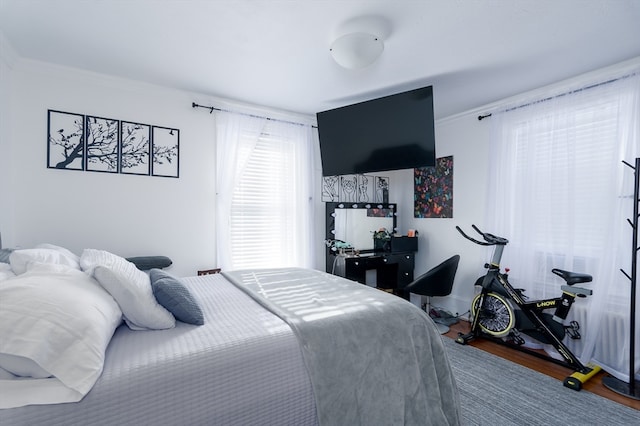 bedroom with hardwood / wood-style flooring and crown molding