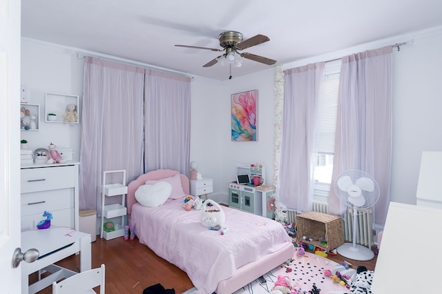 bedroom featuring dark hardwood / wood-style floors, crown molding, and ceiling fan