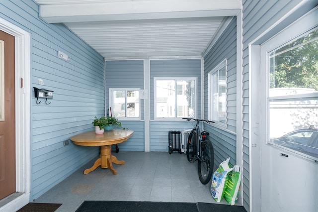 sunroom / solarium featuring beam ceiling