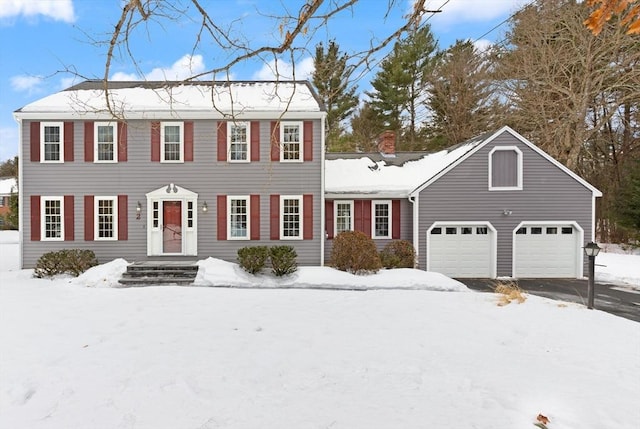 colonial home with an attached garage and aphalt driveway