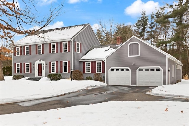 view of front of property with a chimney and aphalt driveway