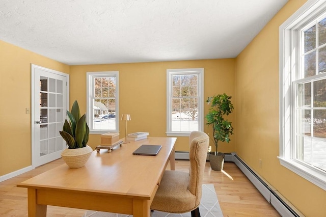 home office featuring light wood-type flooring, a baseboard radiator, a textured ceiling, and baseboards