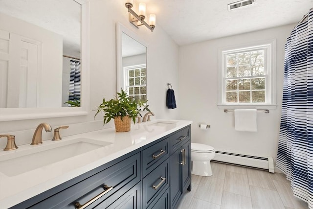 full bathroom with a baseboard heating unit, toilet, a sink, and visible vents