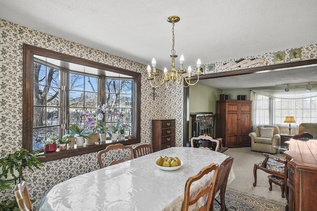 carpeted dining area featuring a textured ceiling, a healthy amount of sunlight, and a notable chandelier