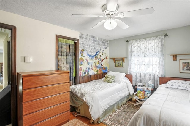 bedroom featuring ceiling fan, a textured ceiling, and hardwood / wood-style flooring