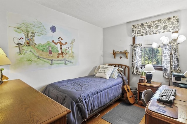 bedroom with wood-type flooring and a textured ceiling